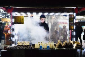 Street vendor at night selling roasted corn and chestnuts in İstanbul, Türkiye.