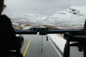 View from a bus through snowy mountains, capturing the serene winter landscape.