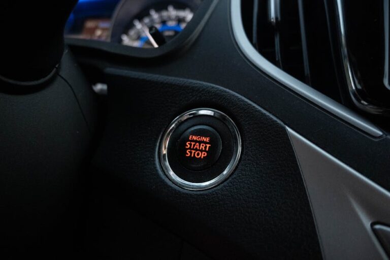 Close-up image of a car's engine start stop button on the dashboard.
