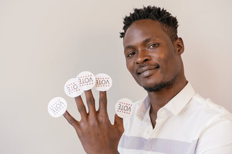 Confident man displaying vote stickers as a representation of democracy and civic engagement.