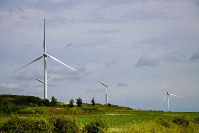Wind turbines generating clean energy in a green field, symbolizing sustainable power solutions.
