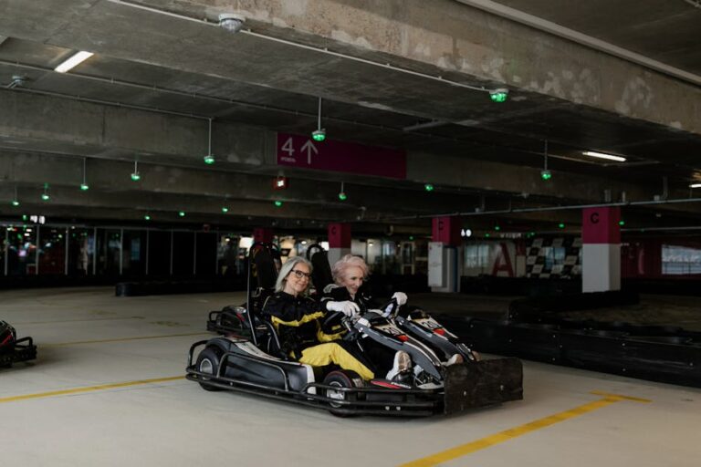 Elderly women enjoy a thrilling go-kart ride in an indoor parking area, showcasing their adventurous spirit.