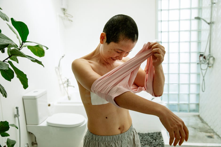 Smiling woman with short hair in a bathroom, embracing recovery joyfully.