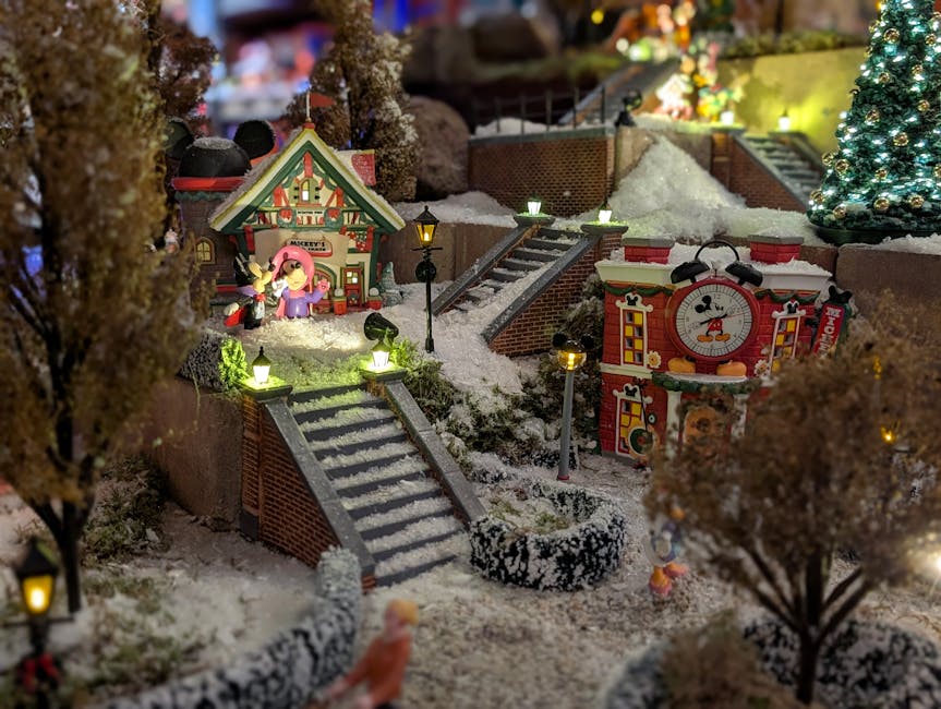 Festive miniature village scene featuring Mickey Mouse in a winter wonderland setting with lights and snow.