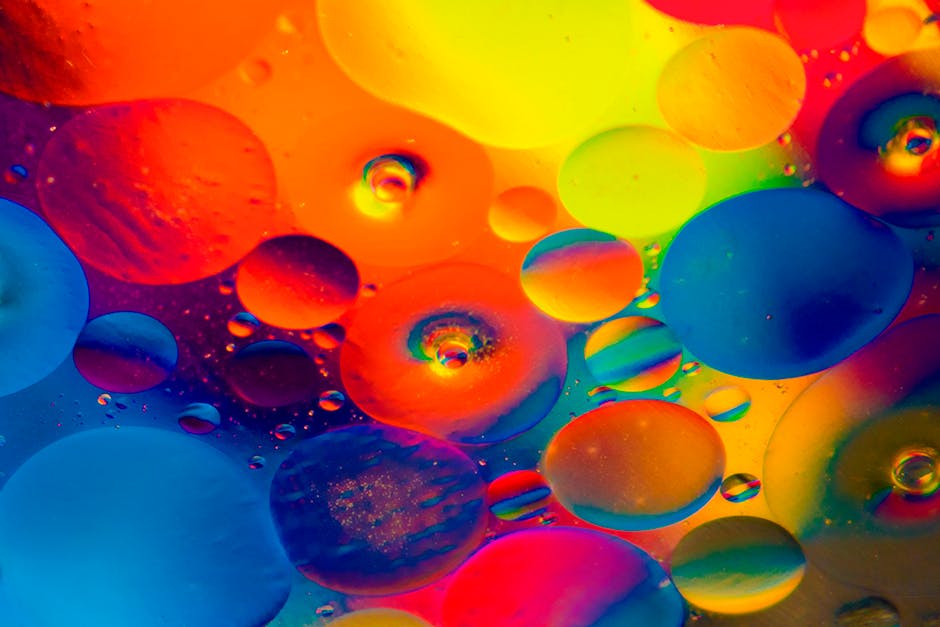 Colorful abstract artwork featuring vibrant bubbles of oil immersed in water, showcasing dynamic color patterns.