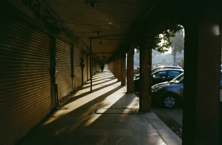Sunlight casting dramatic shadows in Jaipur's quiet morning market, Rajasthan, India.