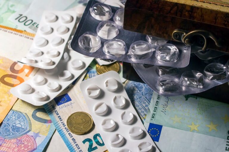 Blister packs of medication placed on Euro banknotes, illustrating healthcare expenses.