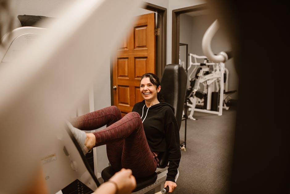 Smiling woman exercising on gym machine indoors, focusing on fitness.