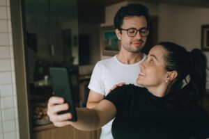 Happy couple capturing a selfie moment at home. Warm and intimate atmosphere.