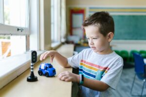 Young boy enjoys playing with toy car indoors, nurturing creativity and fun.