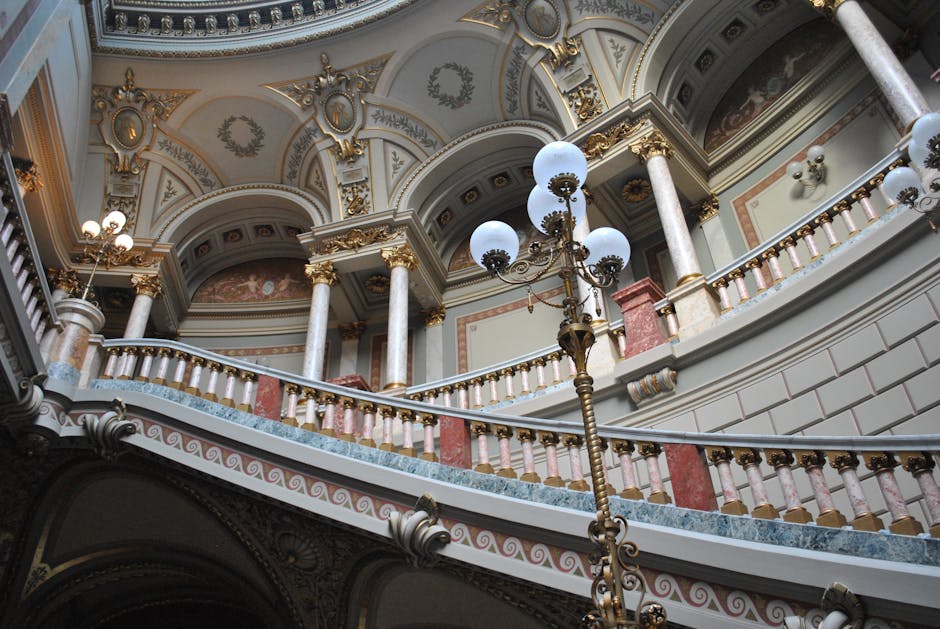 Intricate architectural design of a historical building's staircase with ornate decorations and grand columns.