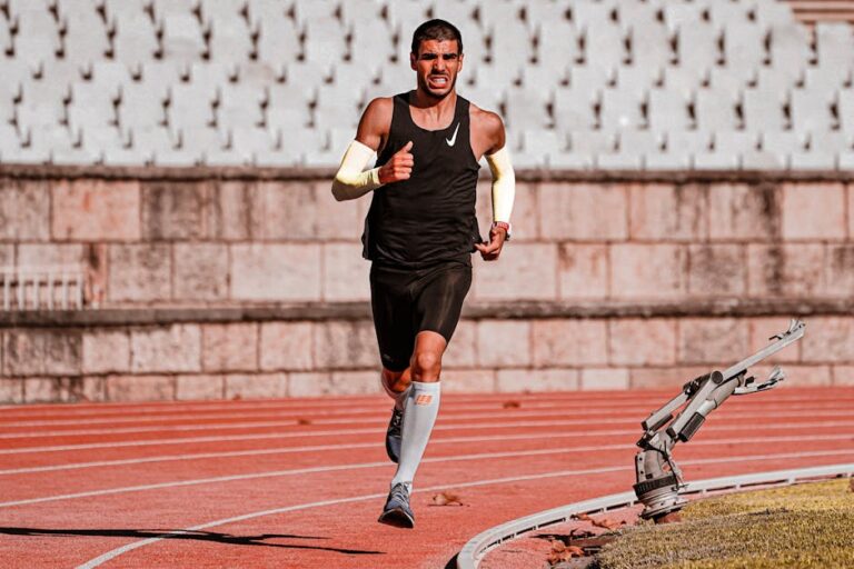Focused male runner during a track race, showcasing determination and endurance.