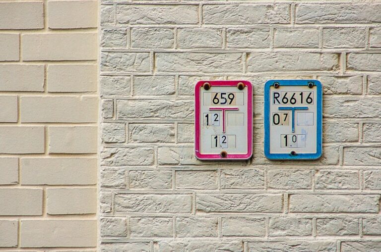Close-up of numbered signs on a brick wall indicating water supply and intake details.