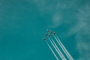 A stunning image of fighter jets performing in formation with contrails in clear skies.