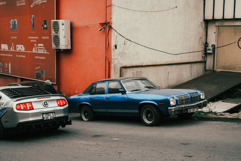 Two classic cars parked outside a building on an urban street corner. Retro and nostalgic vibes.