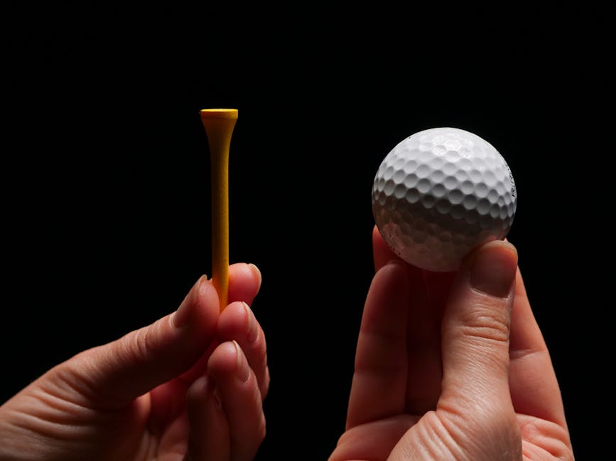 Detailed shot of hands holding a golf ball and tee, perfect for sports enthusiasts.