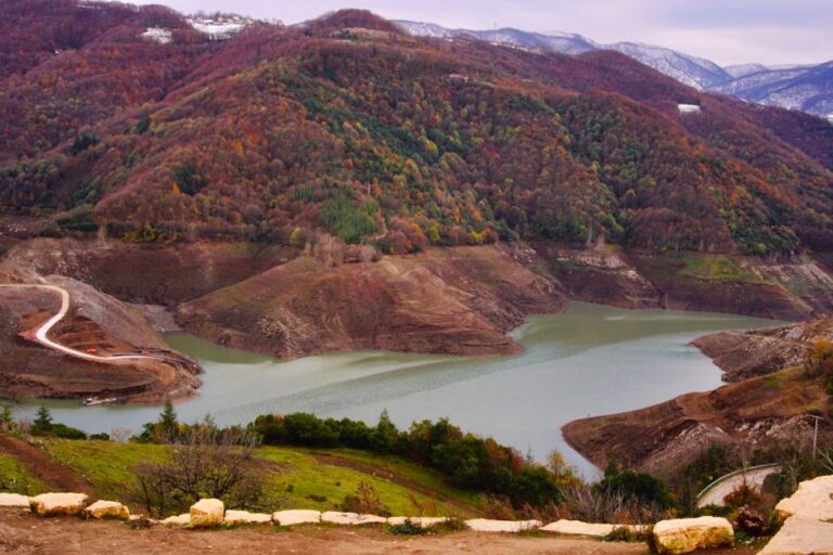 Stunning autumn landscape with vibrant foliage surrounding a serene reservoir.